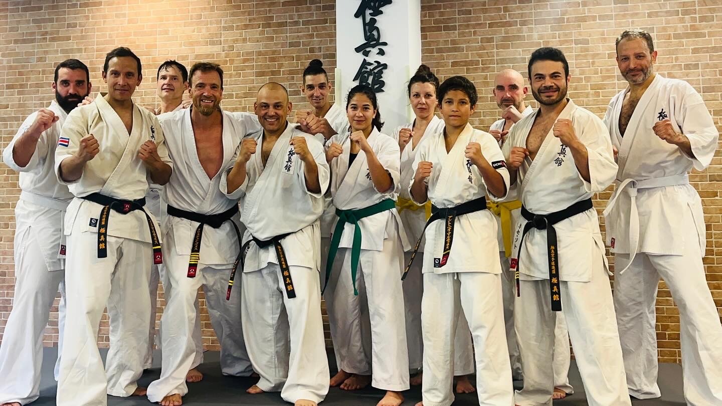 Grupo de Karate Kyokushin para adultos ante la caligrafía del dojo