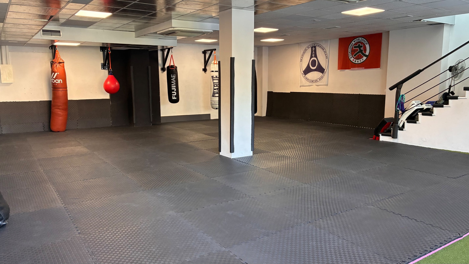 Tatami de Kamae Do en Majadahonda, con sacos y banderas de Kyokushin-kan