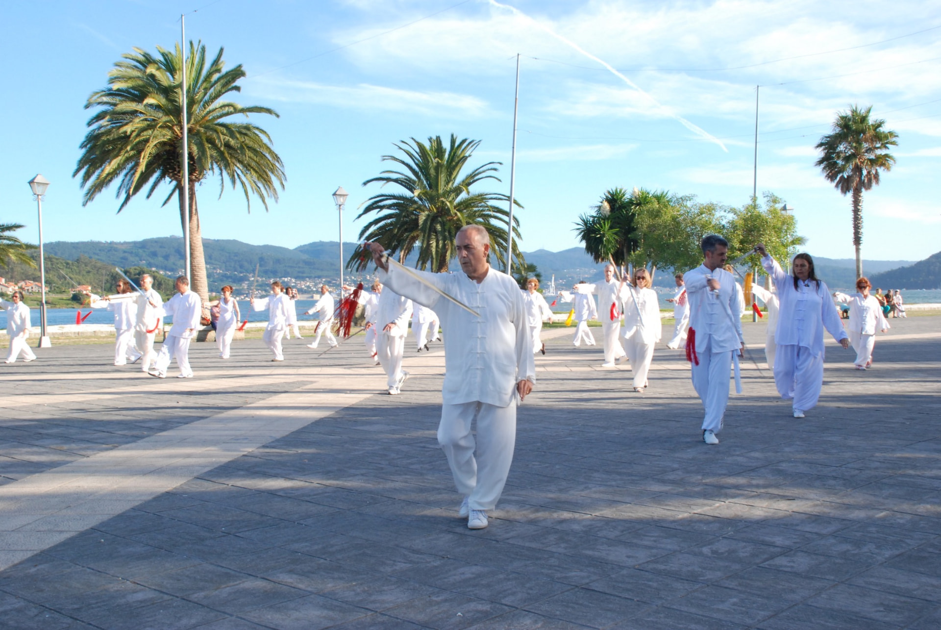 Clase de Taichi con espada al aire libre junto al mar